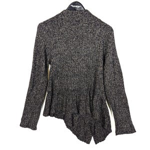 K&ouml;nnte beinhalten: Ein grau-schwarzer Strickpullover mit einem einzigartigen asymmetrischen Saum. Der lang&auml;rmlige Pullover hat eine gerippte Textur und einen hohen Kragen. Das Polo Sport-Etikett ist auf dem Kleiderb&uuml;gel sichtbar.