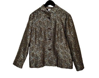 Könnte beinhalten: Eine Knopfjacke mit Paisley-Muster in Gold-, Braun- und Cremetönen. Die Jacke hängt an einem schwarzen Kleiderbügel vor weißem Hintergrund. Sie hat einen hohen Kragen und lange Ärmel.