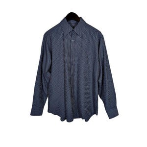 May include: A long-sleeved, button-down shirt in a navy blue and white checkered pattern. The shirt is hanging on a black hanger against a white background. The shirt has a classic collar and buttoned cuffs.