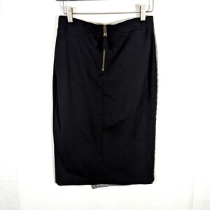 May include: A black pencil skirt with a gold zipper closure at the back. The skirt has a fitted silhouette and a lace detail on the side. The skirt is hanging on a metal hanger against a white background.