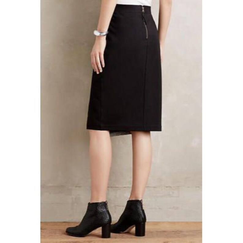 May include: A black pencil skirt with a back zipper and a slit. The skirt is paired with black ankle boots with a textured pattern and block heels. The outfit is suitable for business or casual wear.
