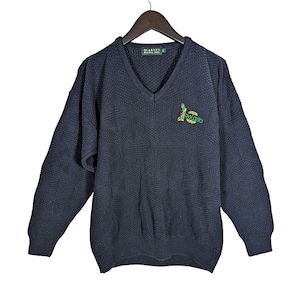 May include: A dark blue v-neck sweater with a green, yellow, and red embroidered logo that says "Relento" on the front. The sweater is made of a textured knit fabric.