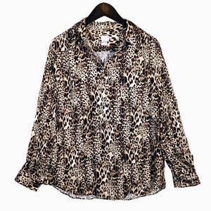May include: A long-sleeved button-down shirt with a leopard print pattern. The shirt features a classic collar, buttoned cuffs, and a chest pocket. The animal print design includes shades of brown, black, and cream.