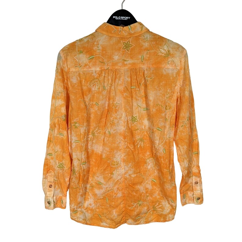 Puede incluir: Camisa naranja de manga larga con bordado floral. La camisa presenta un dise&ntilde;o abotonado y un cuello cl&aacute;sico. El bordado floral es en verde y blanco, contrastando con la tela naranja. La camisa tiene un aspecto texturizado.