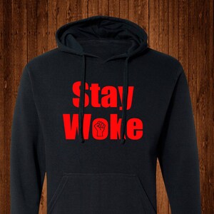May include: Black hooded sweatshirt with a red print that says "Stay Woke" with a raised fist symbol.
