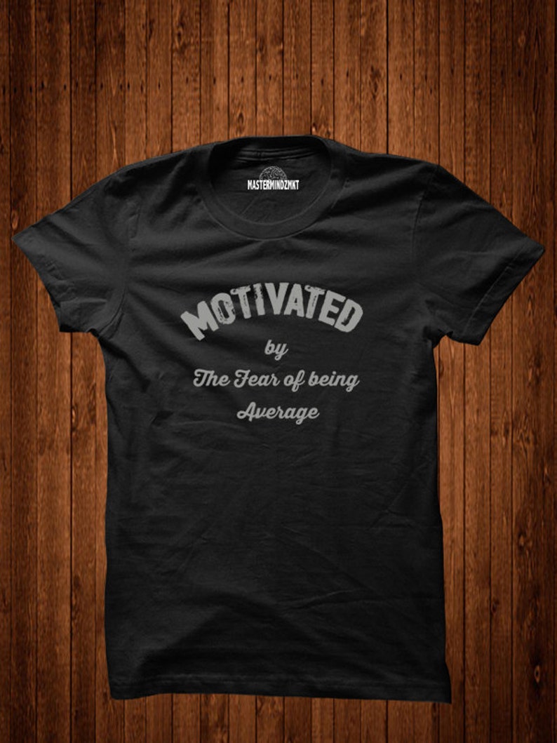 May include: Black t-shirt with the text "Motivated by The Fear of being Average" in white.