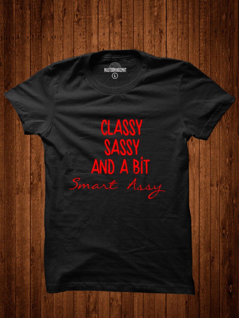 Puede incluir: Camiseta negra con el texto "Classy Sassy And A Bit Smart Assy" en rojo.
