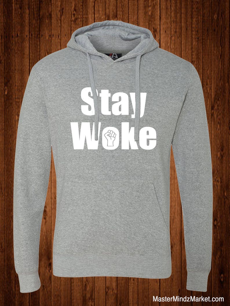 May include: A gray hooded sweatshirt with the text "Stay Woke" in white lettering. A raised fist is included in the text.