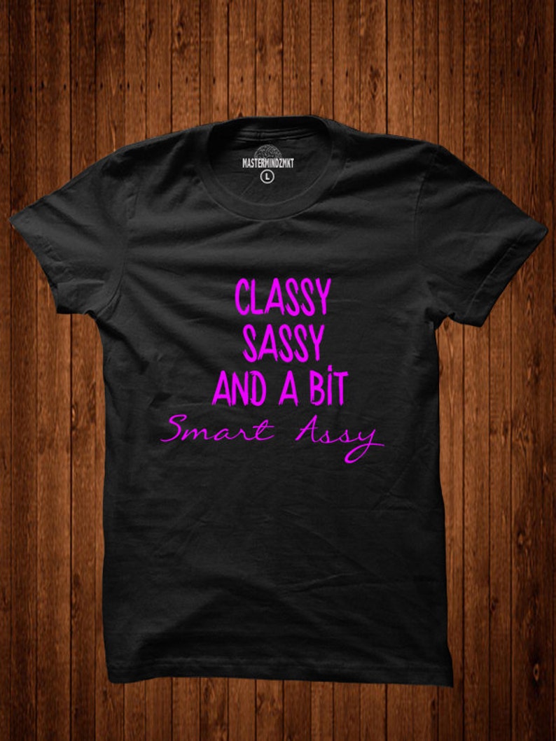 Puede incluir: Camiseta negra con el texto "Classy Sassy And A Bit Smart Assy" en rosa.