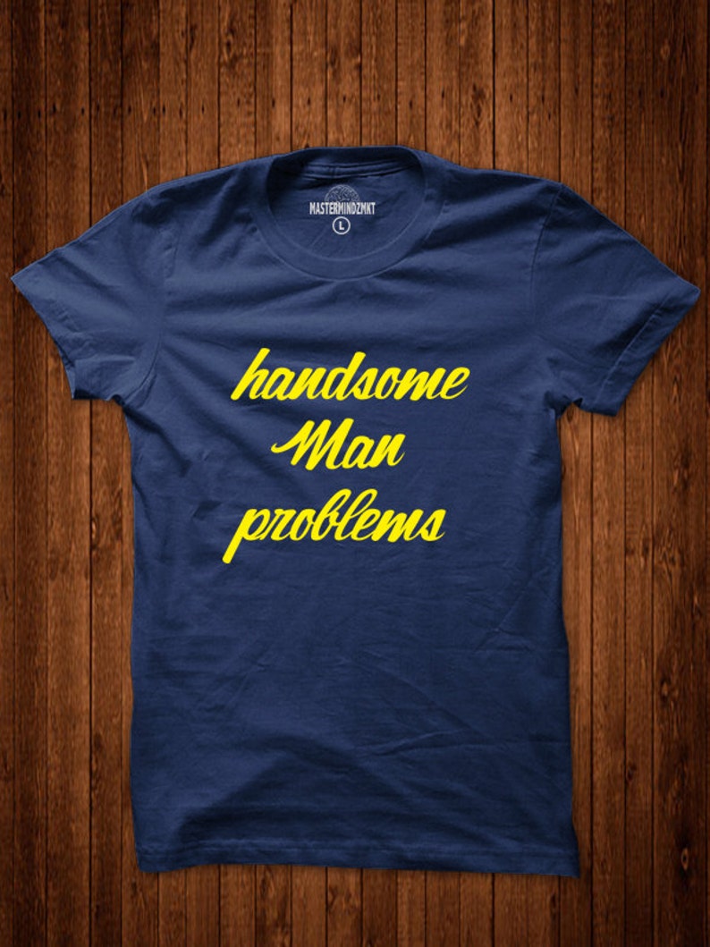 May include: A navy blue t-shirt with the text "handsome man problems" in yellow lettering.