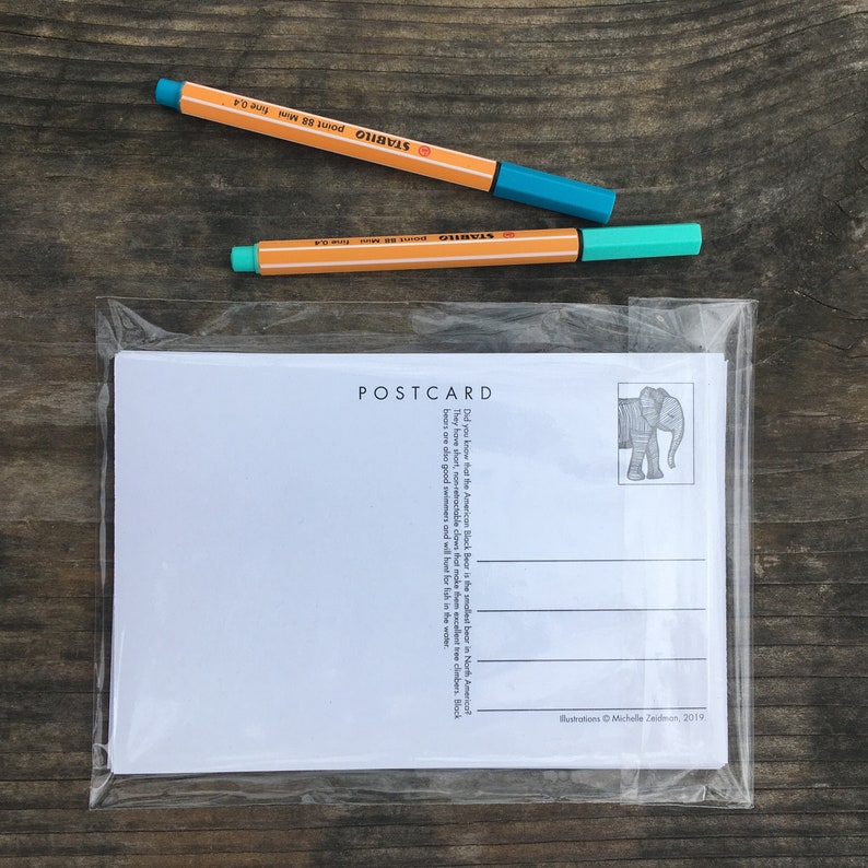 May include: A postcard in a clear plastic sleeve with the word "POSTCARD" at the top. The postcard has an illustration of an elephant and text about American Black Bears. Two orange and teal Stabilo fine point pens are on top.