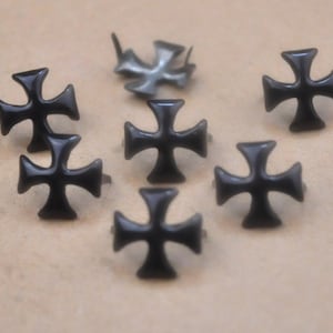 May include: Eight black metal cross-shaped studs with a pointed back for attaching to fabric or leather.