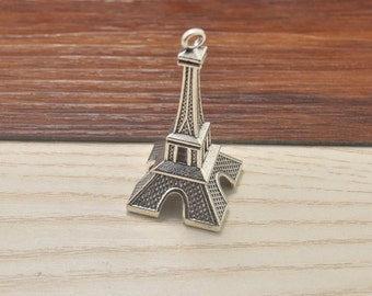 May include: Silver Eiffel Tower charm pendant. The charm is detailed with a textured surface and a loop at the top for attaching to a necklace or bracelet.