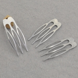 May include: Three silver hair clips with a decorative design. Each clip has five prongs.