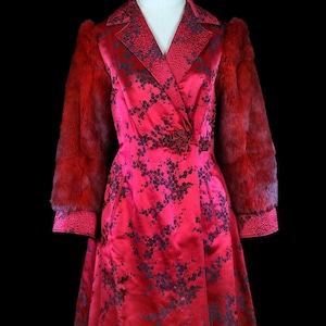 May include: A long red satin robe with a floral pattern and fur-trimmed sleeves. The robe has a shawl collar and a tie closure.