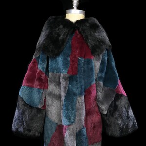 Puede incluir: Un abrigo largo de piel de patchwork con cuello de piel negro. El abrigo está hecho de piezas de piel de diferentes colores, incluyendo azul verdoso, gris y burdeos.