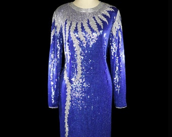 May include: A long-sleeved, royal blue sequined dress with a silver sequined design. The design features a series of vertical lines and a large, abstract shape.