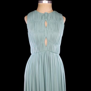 May include: A light blue sleeveless maxi dress with a keyhole neckline and a gathered bodice. The dress has a simple, elegant design.