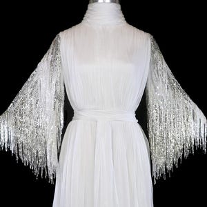 Bob Mackie beaded fringe gown ivory off white red carpet wedding dress long sleeve open back silver sequins sash belted 1970s 1980s couture
