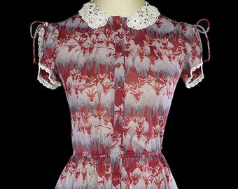May include: A red and white patterned dress with a white lace collar and short sleeves. The dress has a button-up front and a full skirt.