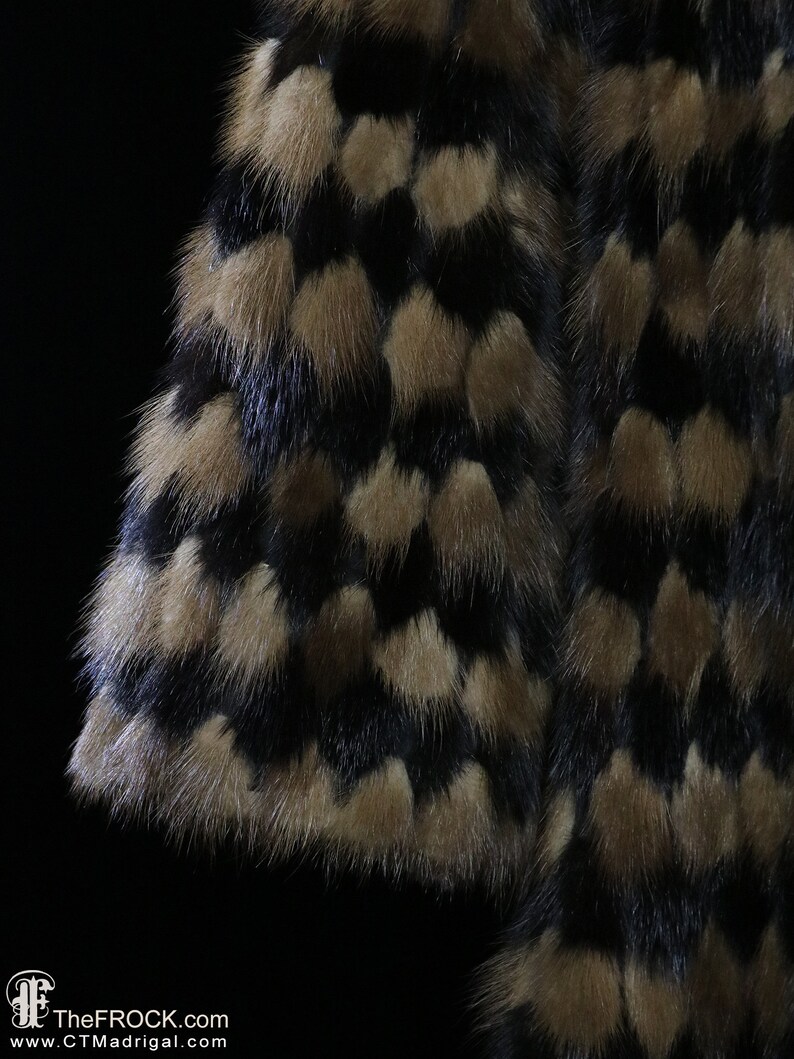 May include: Close-up of a black and brown fur fabric with a patterned design. The fur is soft and fluffy.