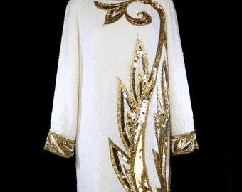 Bob Mackie cocktailjurk met lange mouwen, versierd met kralen en pailletten, ivoorkleurig, goudkleurig, metallic, vlammend, met kralen.
