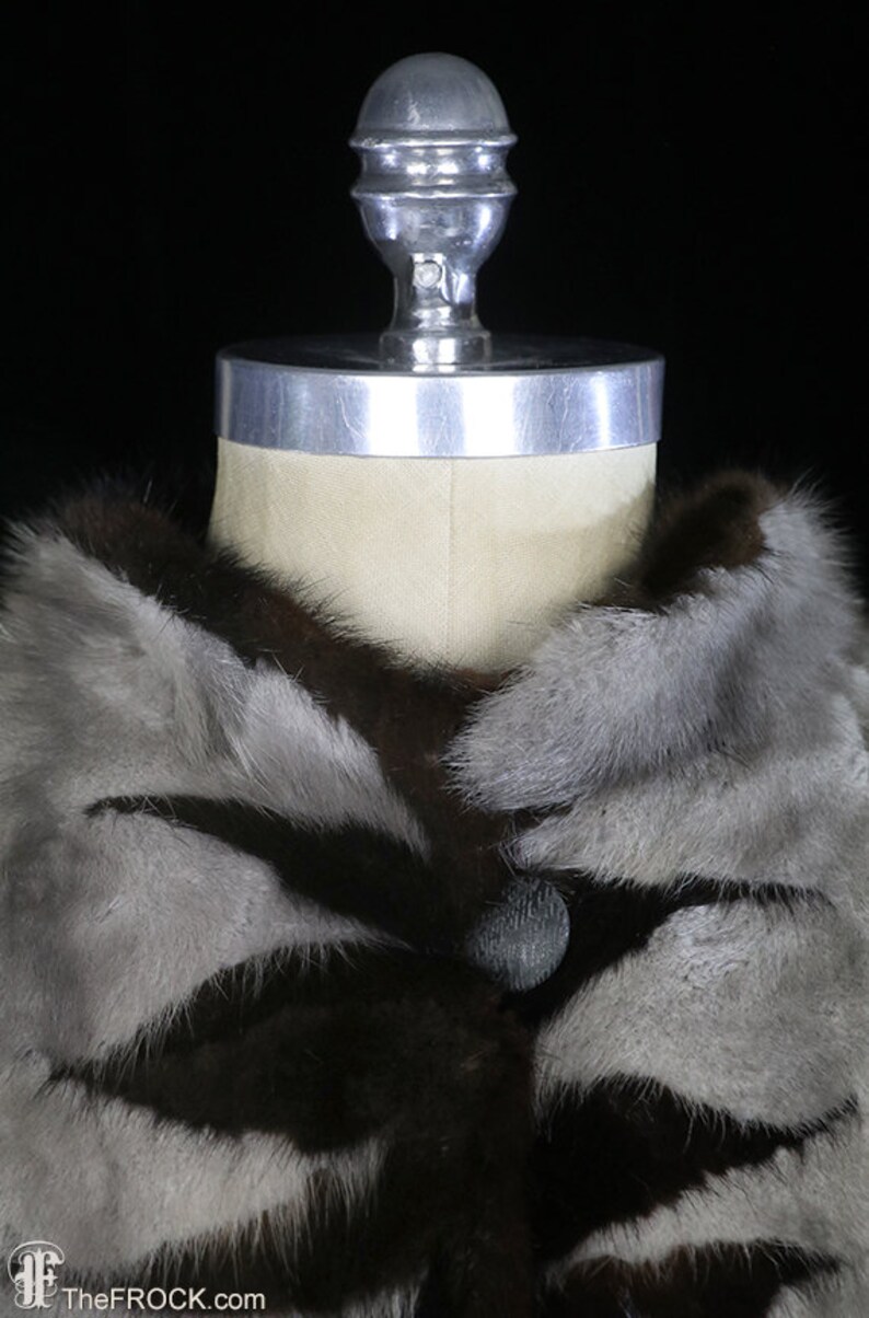 May include: A brown and gray fur coat with a large collar and a single button closure.
