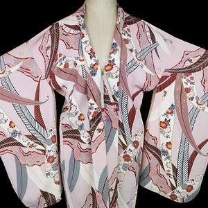 May include: A pink kimono with a floral and leaf pattern. The kimono has long sleeves and a V-neck.