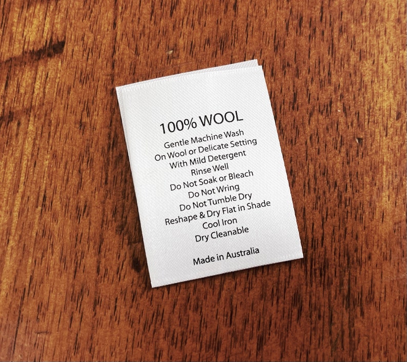 May include: White care label with black text that reads "100% WOOL" and instructions for washing, drying, and ironing wool garments. The label also states "Made in Australia."