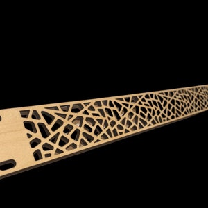 May include: A long, thin, wooden panel with a geometric, intricate, laser-cut design. The panel is light brown and the cut-out design is black.