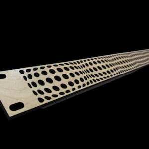 May include: A wooden panel with a black, repeating pattern of circles. The panel has two holes on the left side.