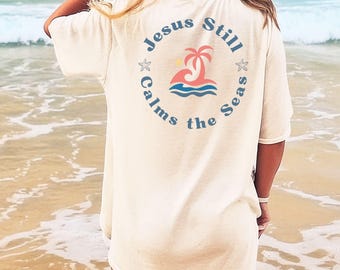 Camiseta de playa cristiana con diseño de Jesús aún calma los mares / Sudadera o camiseta con bolsillo de la colección Fe Costera.