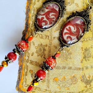Orecchini "Hoggar" boemi Sciarpa maghrebina ricamata della fine del XVIII secolo, vetro rosso di Boemia, agata, vetro rosso lavorato a lume, metallo bronzo