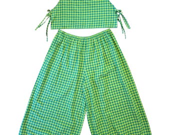 Peut inclure: Un ensemble deux pièces composé d'un haut court sans manches et d'un pantalon large. Les deux pièces présentent un motif à carreaux vert et jaune. Le haut court a une encolure ronde et des liens sur les côtés, le pantalon a une taille élastique.