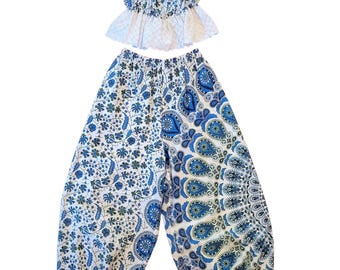 May include: A two-piece outfit consisting of a cropped camisole top with thin tie-shoulder straps and a ruffled hem, paired with loose-fitting trousers. Both pieces feature a white base with intricate blue and green floral and paisley patterns.