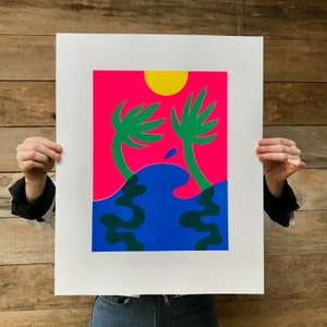 Peut inclure: Une impression abstraite rose et bleue avec deux palmiers verts et un soleil jaune. L'impression présente un motif de vague stylisé.