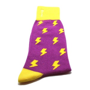 May include: Purple socks with a yellow lightning bolt pattern. The socks have a yellow cuff.