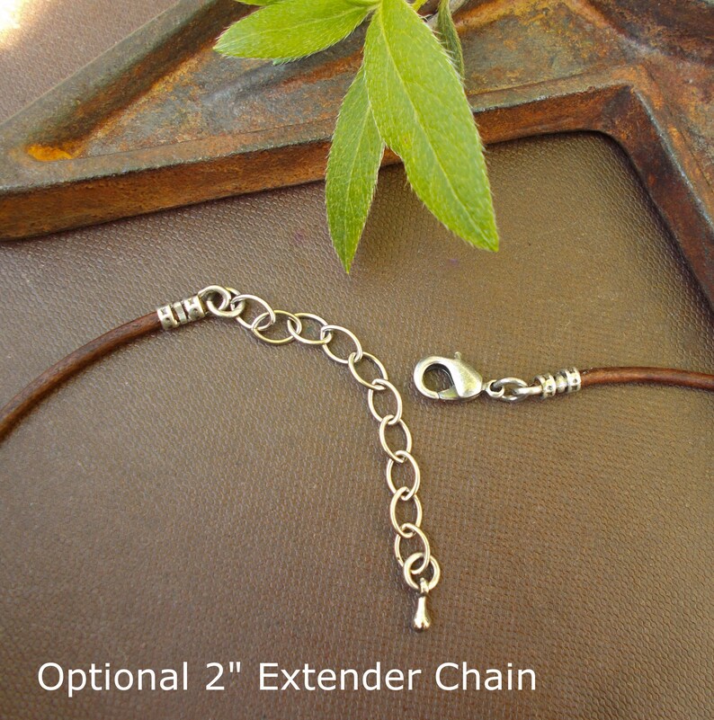 May include: A brown leather cord necklace with a silver extender chain. The chain is 5 cm long and has a lobster clasp.  Optional 2" Extender Chain.
