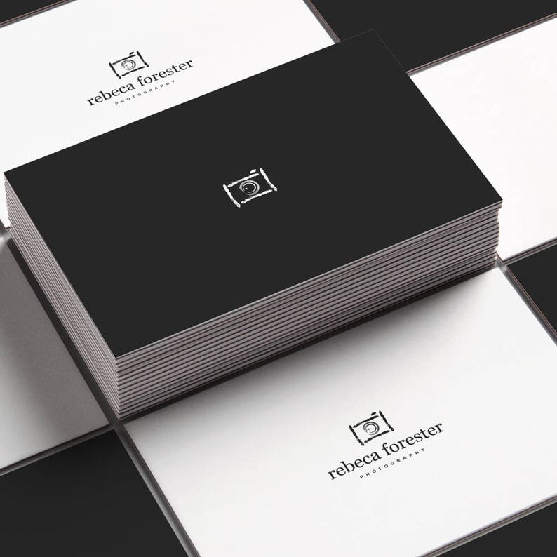 May include: A stack of black business cards with a white camera icon and the text "rebecca forester photography" on the front.