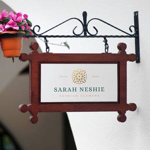 May include: A wooden sign with a gold and green logo that says "Sarah Neshie Premium Flowers" and "Estd 2000". The sign is hanging from a black metal bracket.
