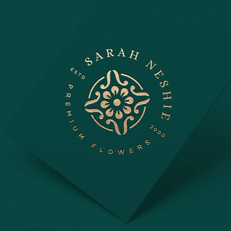 May include: Gold logo on a dark green background with the text "Sarah Neshie Premium Flowers Est. 2000" in a circle with a floral design in the center.