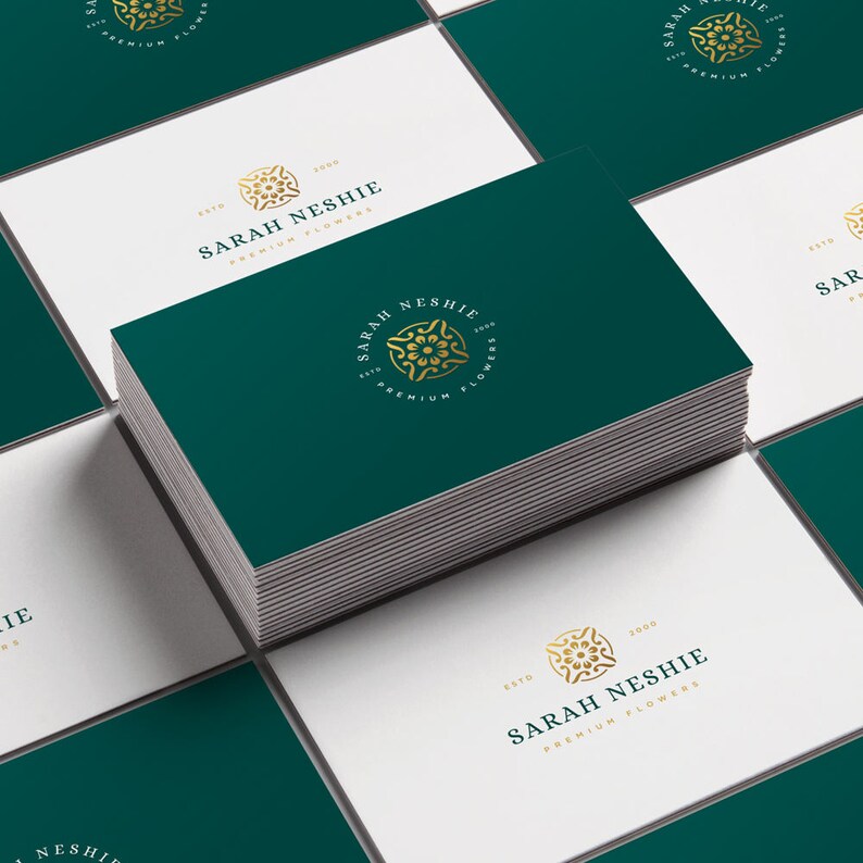 May include: A stack of green business cards with a gold logo featuring a stylized flower and the text "Sarah Neshie, Est. 2000, Premium Flowers".