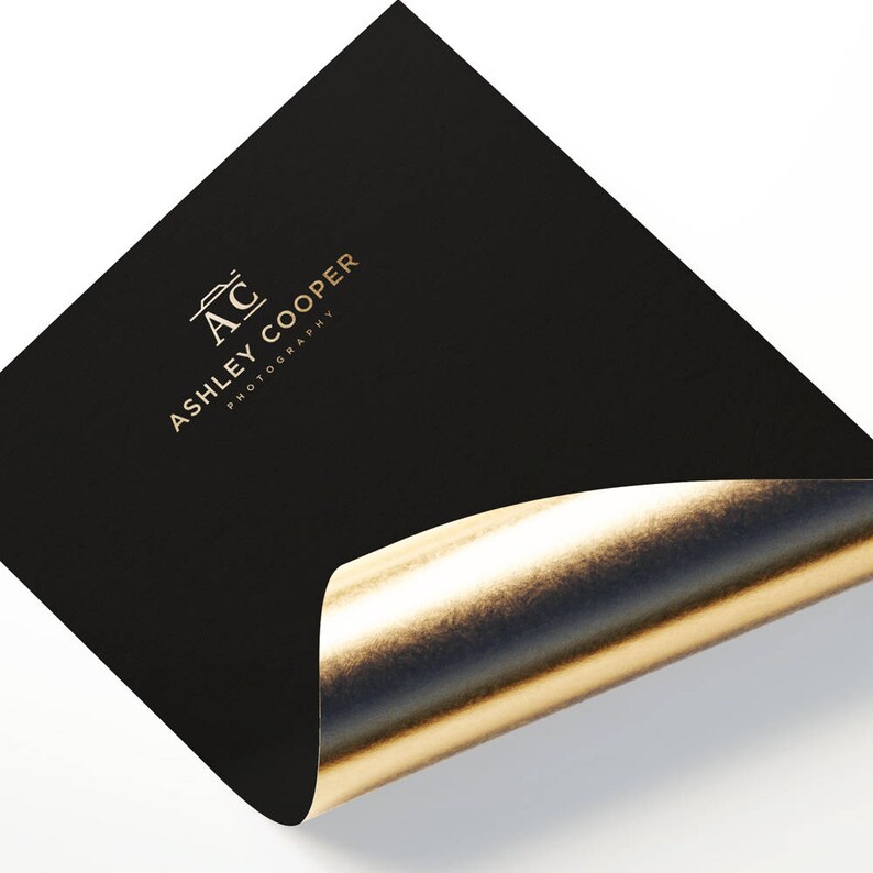 Puede incluir: Tarjeta negra con interior de l&aacute;mina dorada, con el texto dorado "AC ASHLEY COOPER PHOTOGRAPHY". La tarjeta est&aacute; ligeramente curvada, revelando la brillante l&aacute;mina dorada debajo.