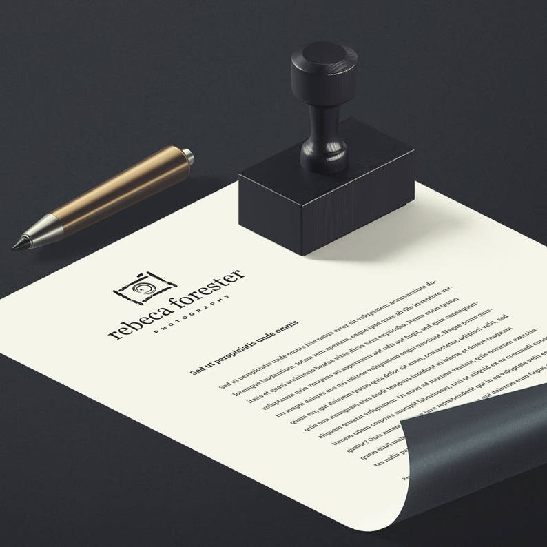 May include: A white sheet of paper with a black rubber stamp and a gold pen on a black surface. The paper has a logo for "rebecca forester photography" and the text "Sed ut perspiciatis unde omnis..."