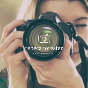 May include: A woman holding a black camera with a lens that has a white logo that says "rebeca forester photography" and a stylized camera icon.