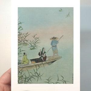 Op de afbeelding: Een prent van een Japanse houtsnede die drie figuren in een boot op een meer afbeeldt. De figuren dragen traditionele kleding. De achtergrond toont riet, vogels en een zachte blauwe lucht.
