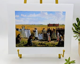 Puede incluir: Una impresión enmarcada de una pintura que representa una procesión religiosa en un campo. La obra presenta figuras con ropa blanca y oscura, con un dosel rojo. El fondo muestra un campo de trigo bajo un cielo azul con nubes. La impresión se exhibe en un caballete dorado.