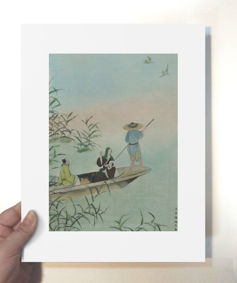 Op de afbeelding: Een ingelijste prent van een traditioneel Japans schilderij met figuren in een boot op een meer. Het kunstwerk heeft zachte kleuren, met een man met een strohoed en anderen in de boot. Riet en vogels zijn ook zichtbaar.