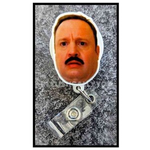May include: A white plastic badge holder with a retractable reel. The front of the badge holder features a printed image of a man with a mustache.
