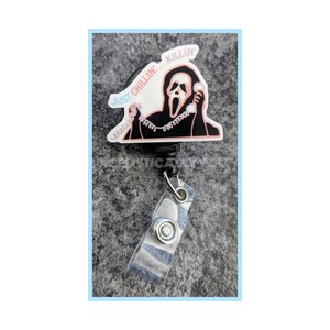 May include: A black retractable badge holder with a white and pink Ghostface character from the Scream movie franchise. The character is holding a phone and the text "Just Chillin...Killin'" is above the character.